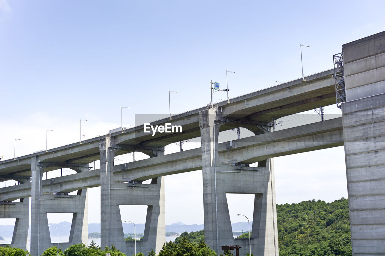 LOW ANGLE VIEW OF ELEVATED BRIDGE OVER RIVER