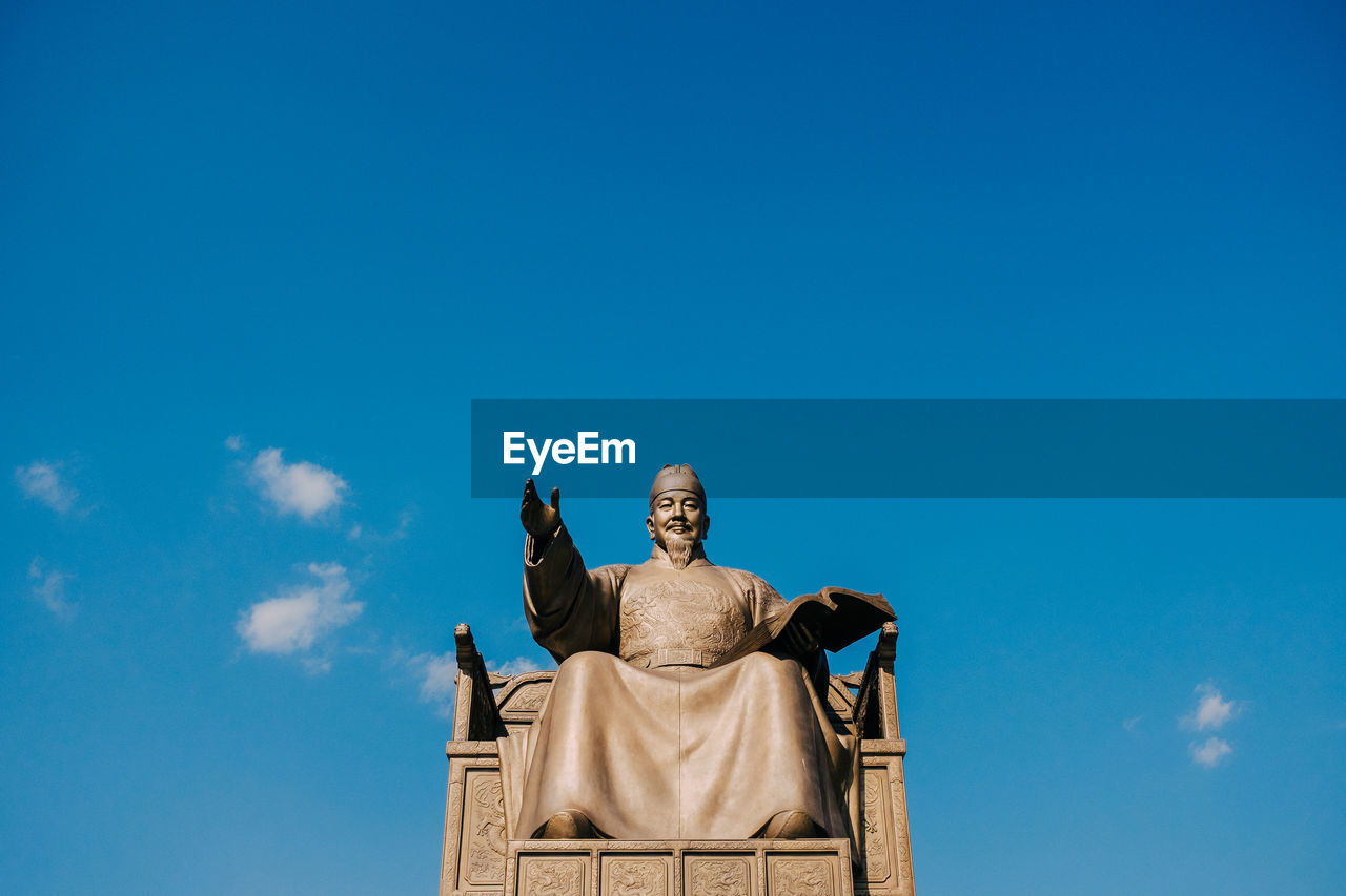 Low angle view of statue against blue sky