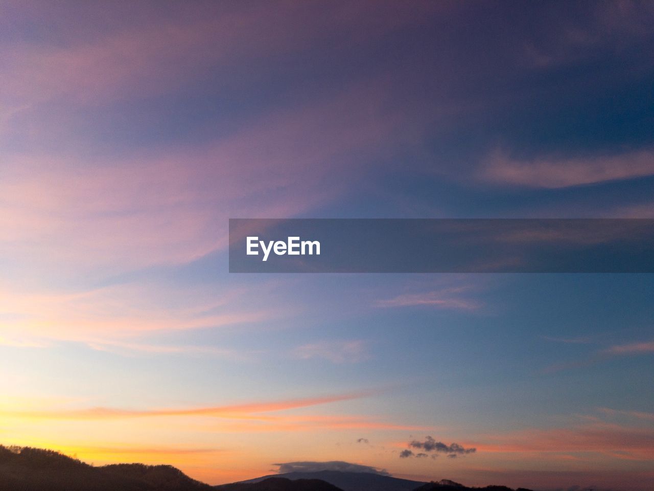 LOW ANGLE VIEW OF SILHOUETTE MOUNTAIN AGAINST DRAMATIC SKY