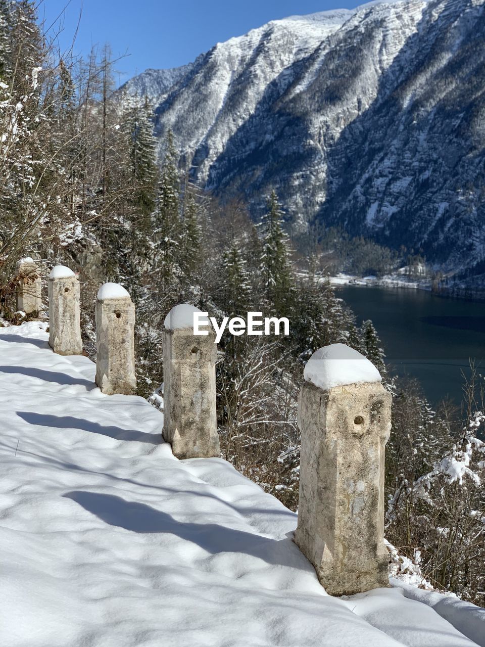 Scenic view of snow covered field by mountain in hallstatt austria    