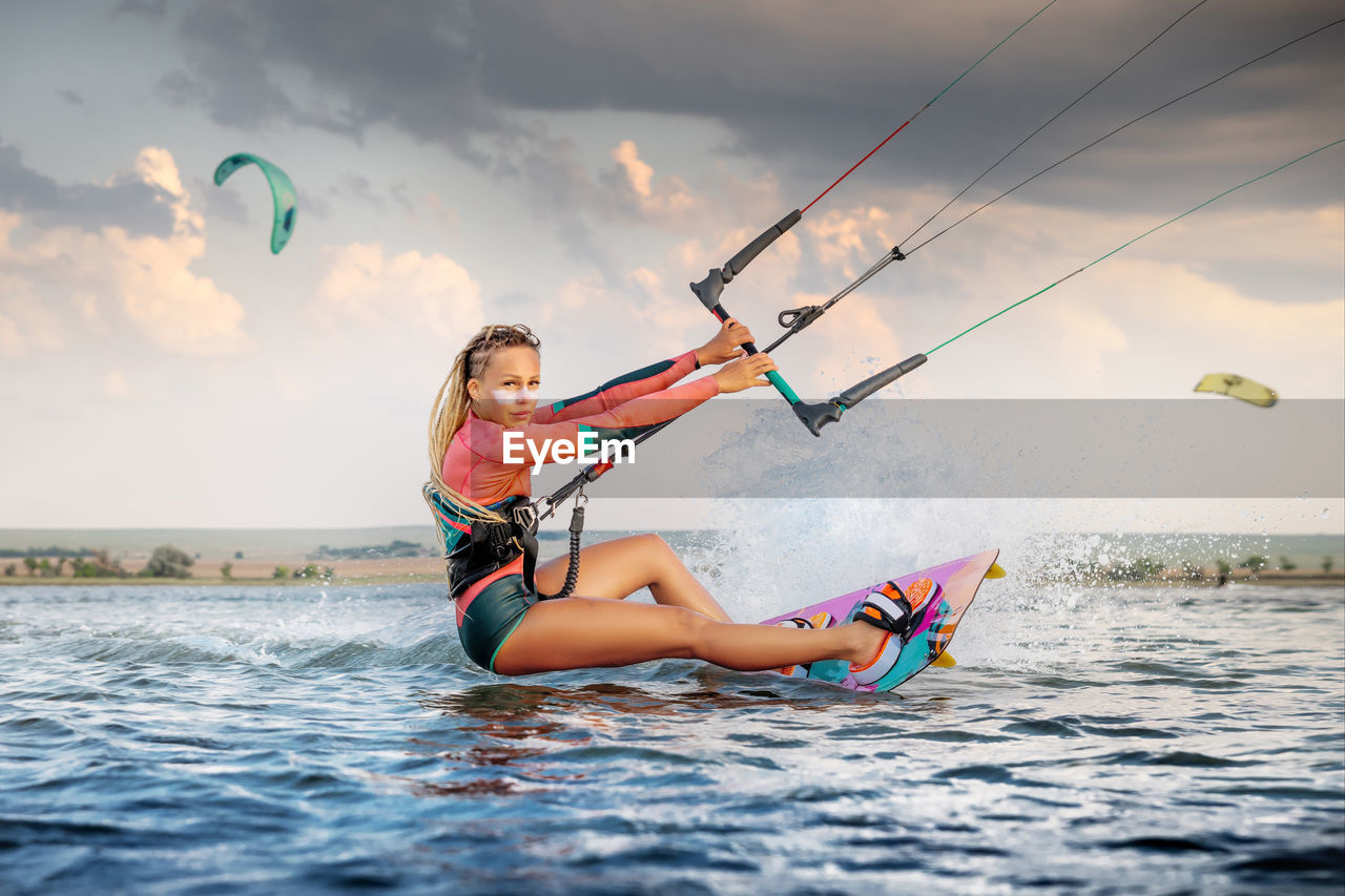 Woman kitesurfing at sea