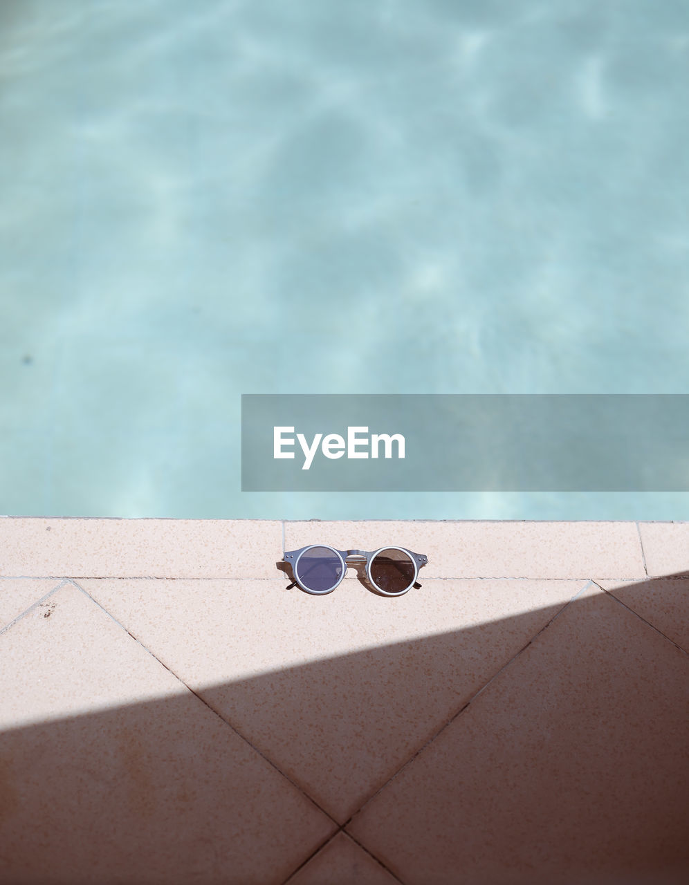 High angle view of sunglasses on poolside