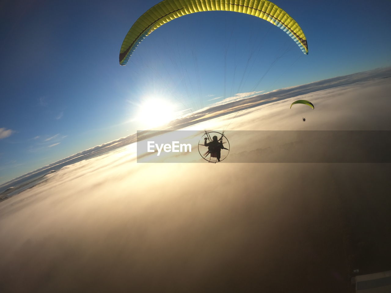 Low angle view of person paragliding against clouds