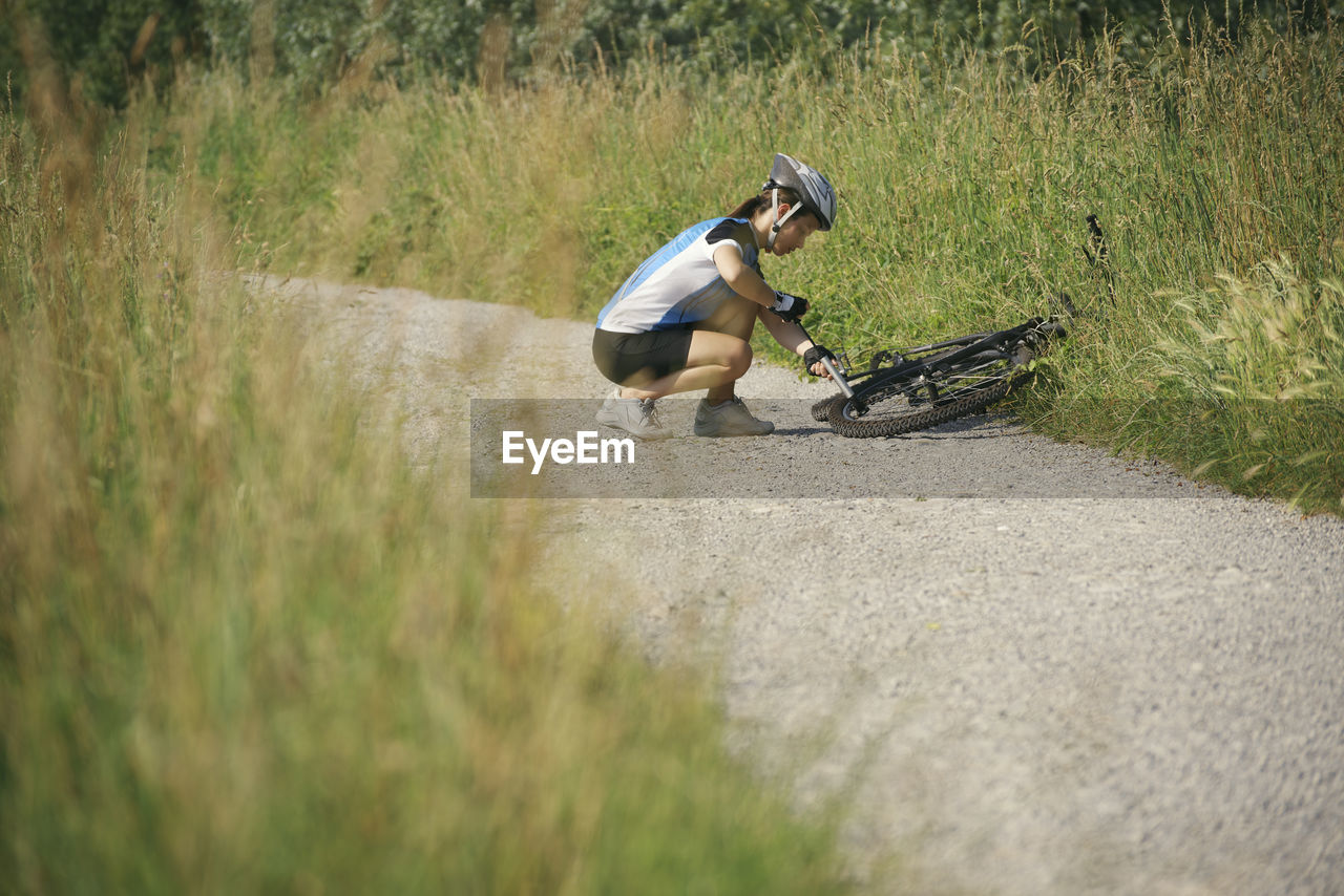 Side view of woman repairing bicycle