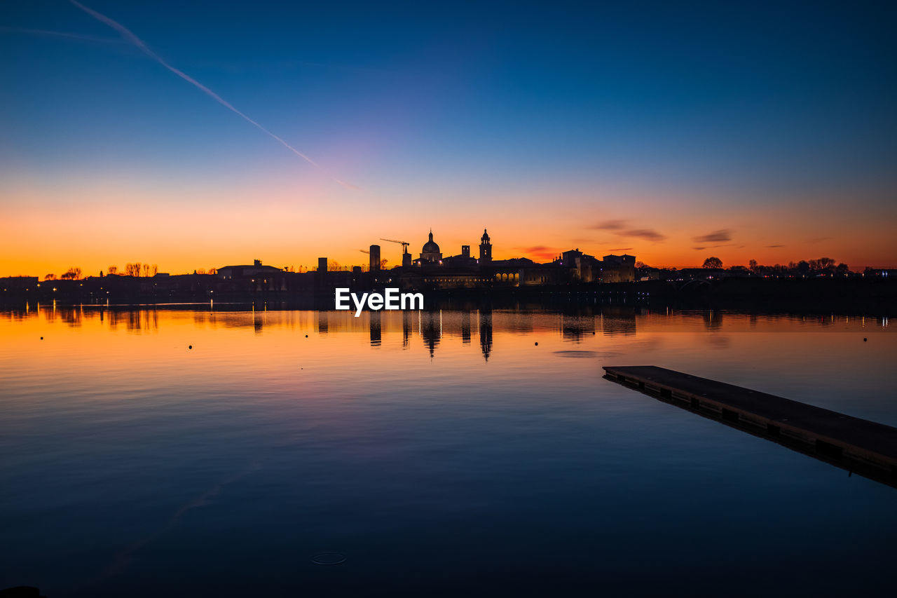 Scenic view of  mantua's old town by silhouette buildings against sky during sunset