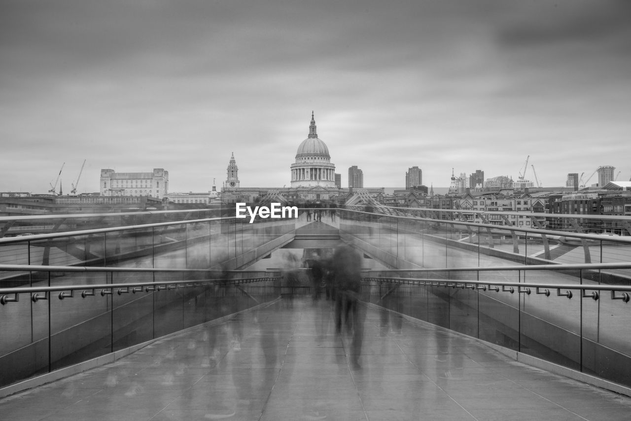 Blurred motion of people walking on london millennium footbridge against st paul cathedral