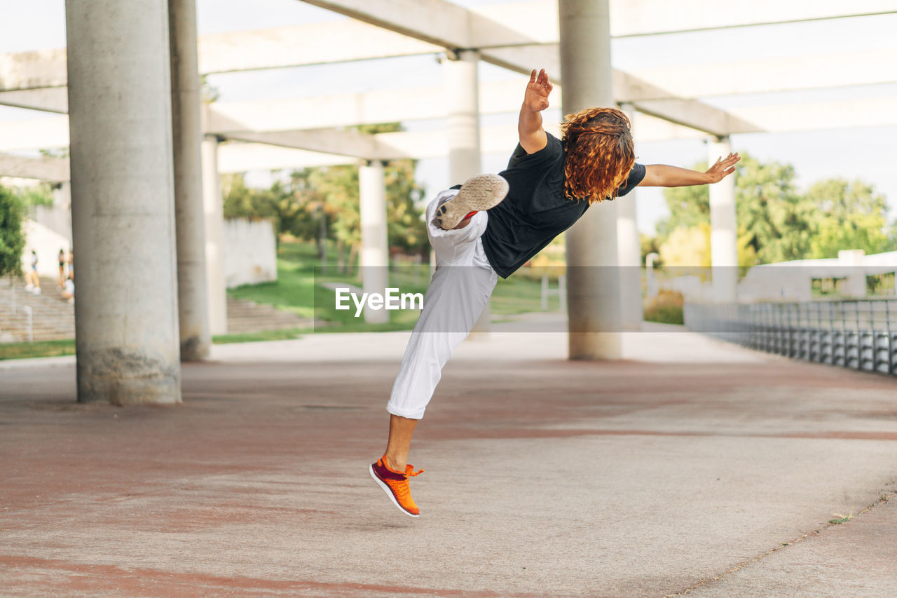 Acrobat practicing jump while exercising at park