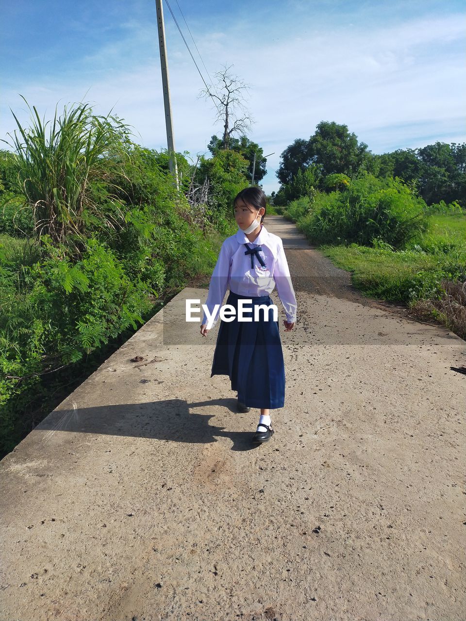 Rear view of woman walking on road