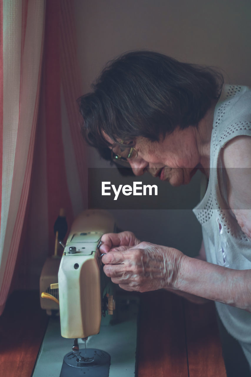 Senior woman working on sewing machine
