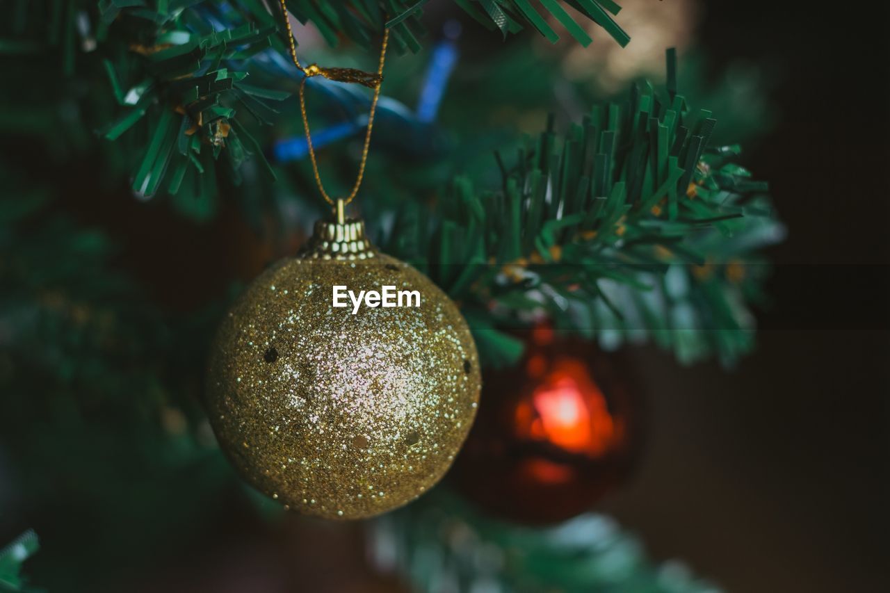 Golden christmas ball. golden glitter. close-up of christmas decoration hanging on tree