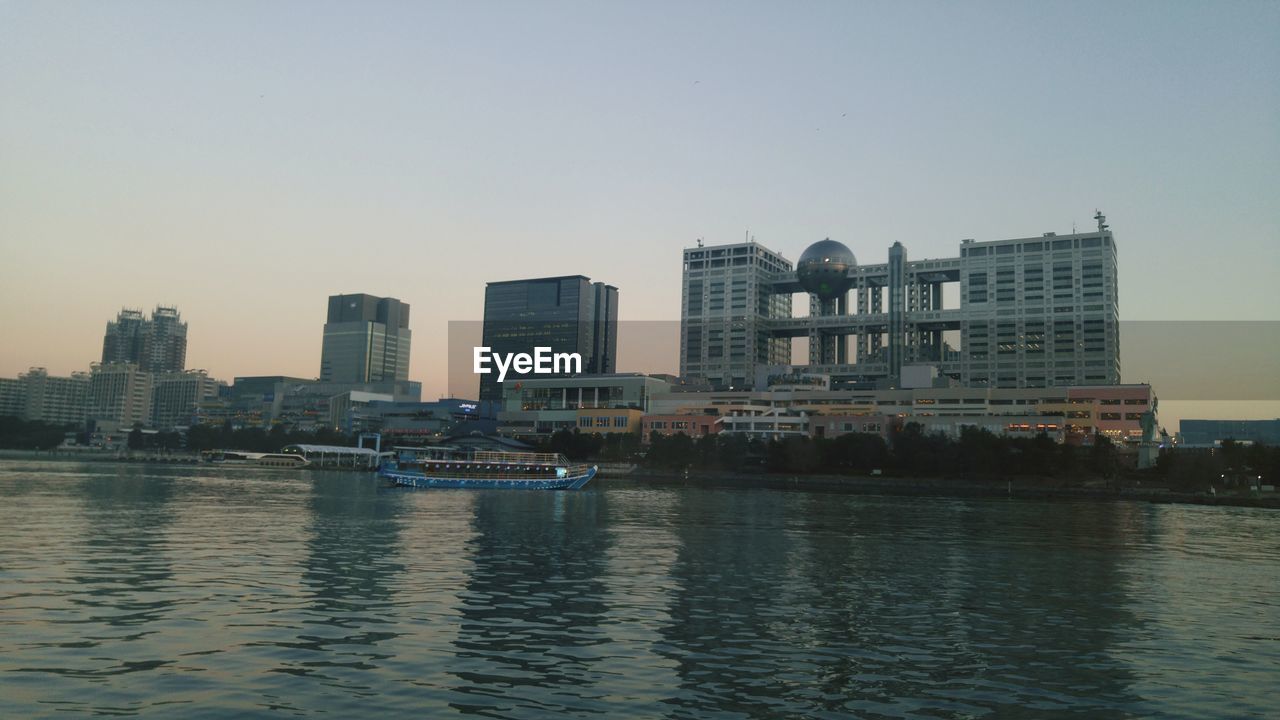 VIEW OF RIVER AND CITYSCAPE AGAINST CLEAR SKY