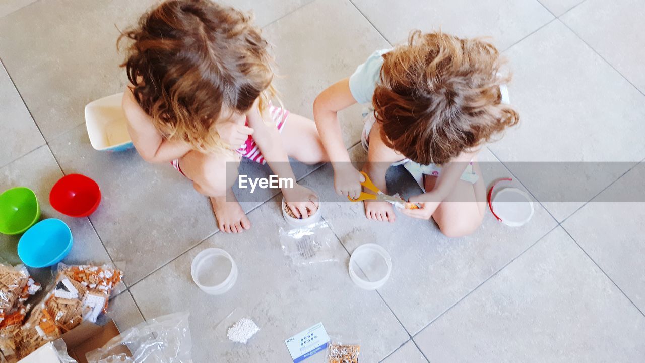 High angle view of girls playing on floor at home