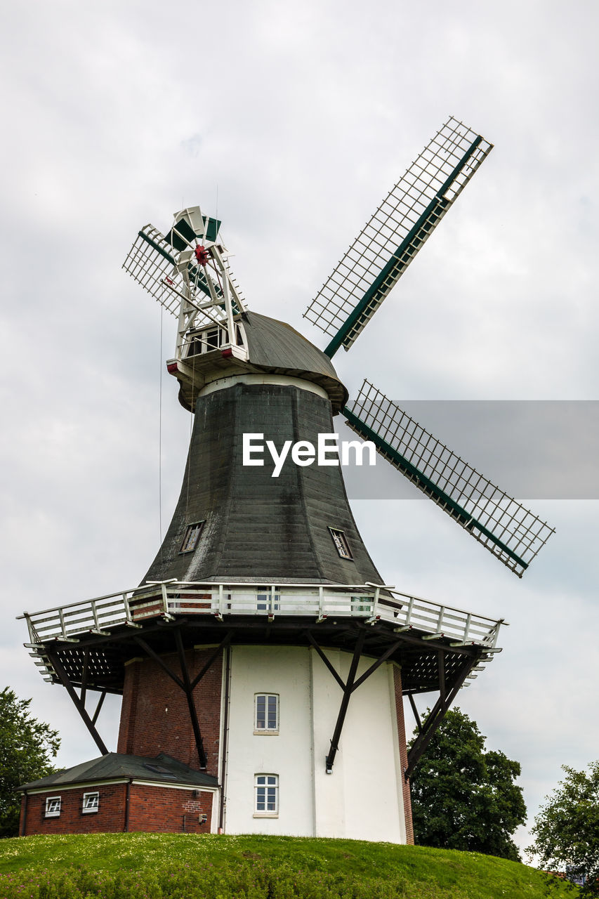 TRADITIONAL WINDMILL AGAINST CLOUDY SKY