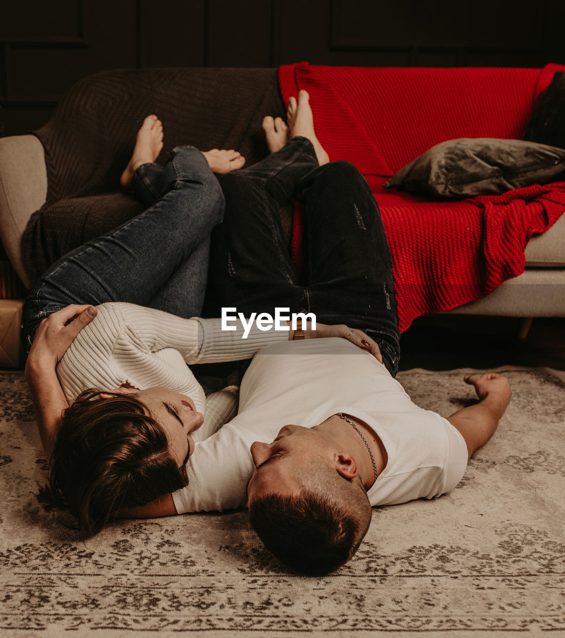 Young couple lying on floor at home