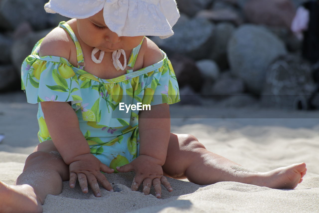 rear view of cute baby boy sitting at beach