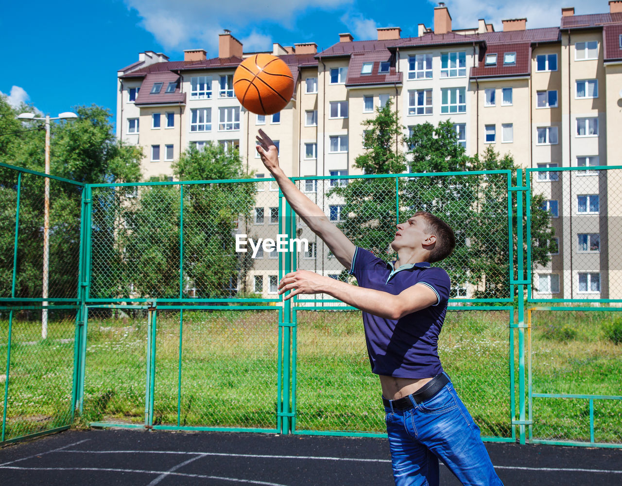 Man playing with basketball at court