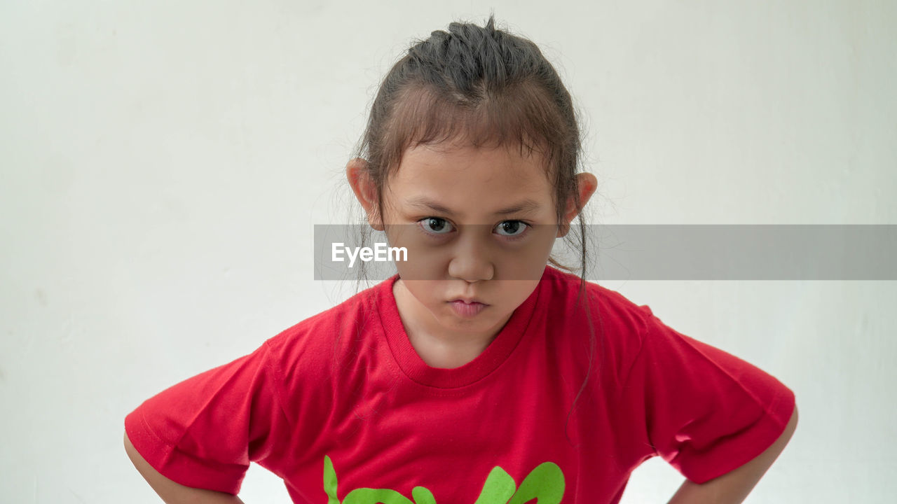 child, childhood, portrait, red, one person, looking at camera, front view, toddler, indoors, person, hairstyle, men, pink, white background, t-shirt, teenager, emotion, studio shot, innocence, copy space, casual clothing, cute, sleeve, waist up, clothing, smiling, human face, headshot, serious, lifestyles, standing