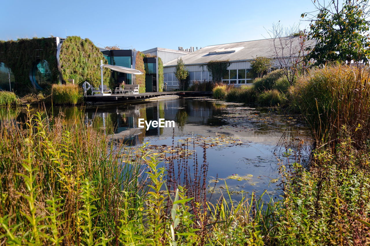 SCENIC VIEW OF LAKE BY BUILDINGS AGAINST CLEAR SKY