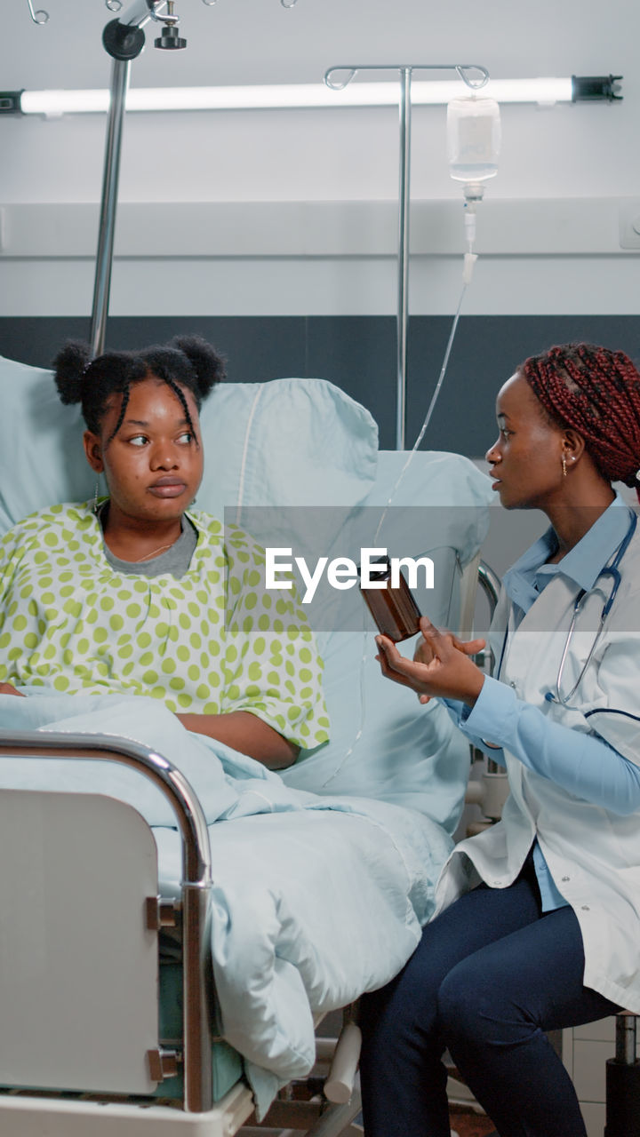 Female doctor giving medicine to patient