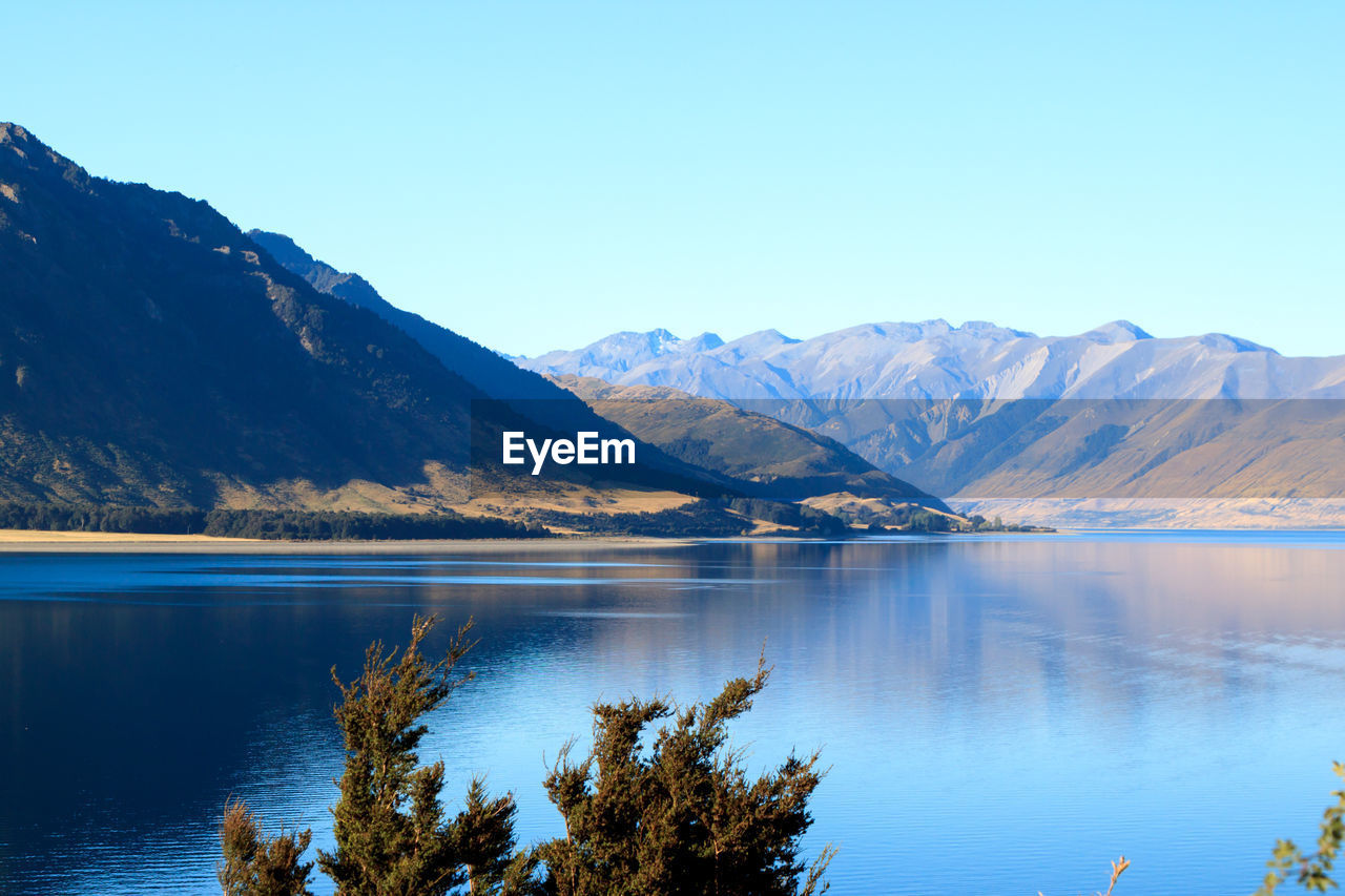 SCENIC VIEW OF MOUNTAINS AND LAKE AGAINST CLEAR SKY