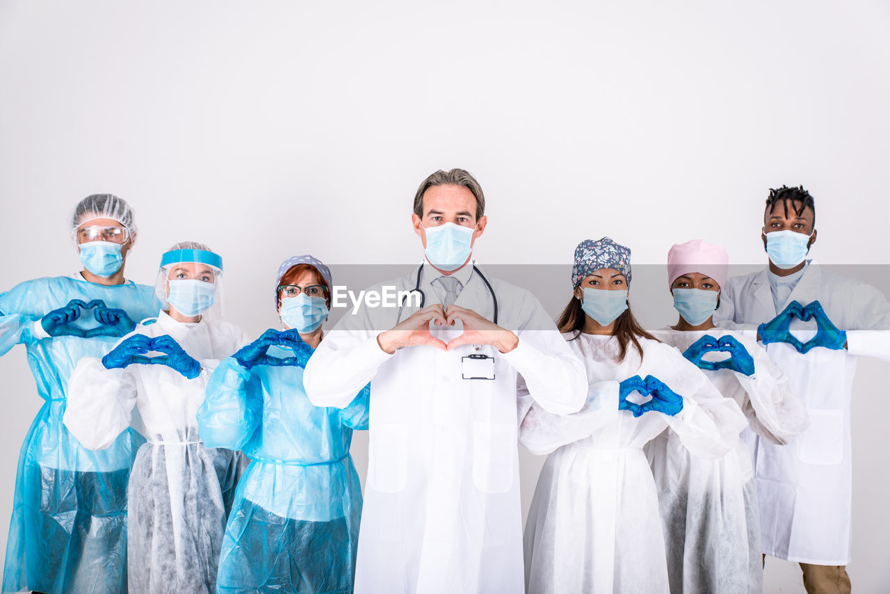 Doctors wearing mask standing against white background