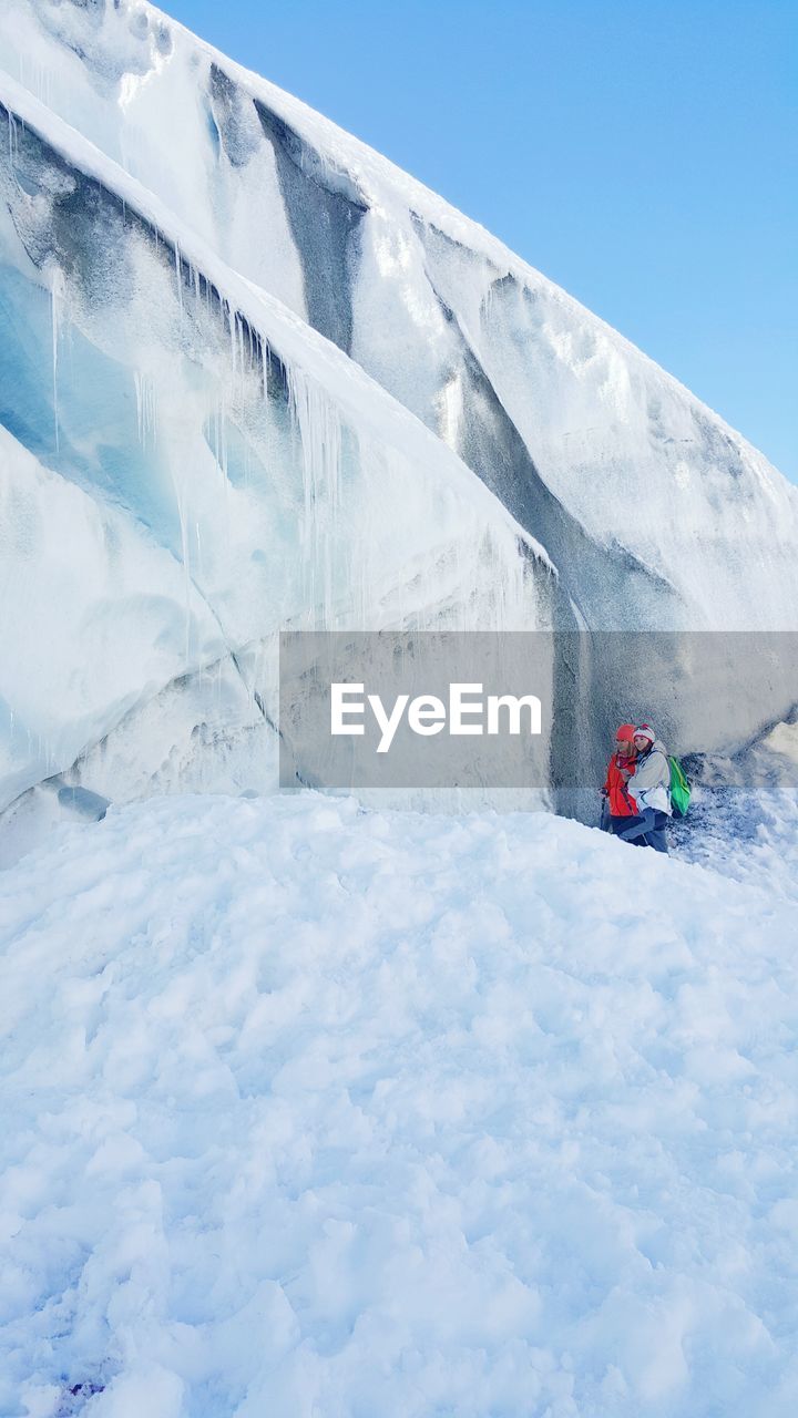 People standing by glacier