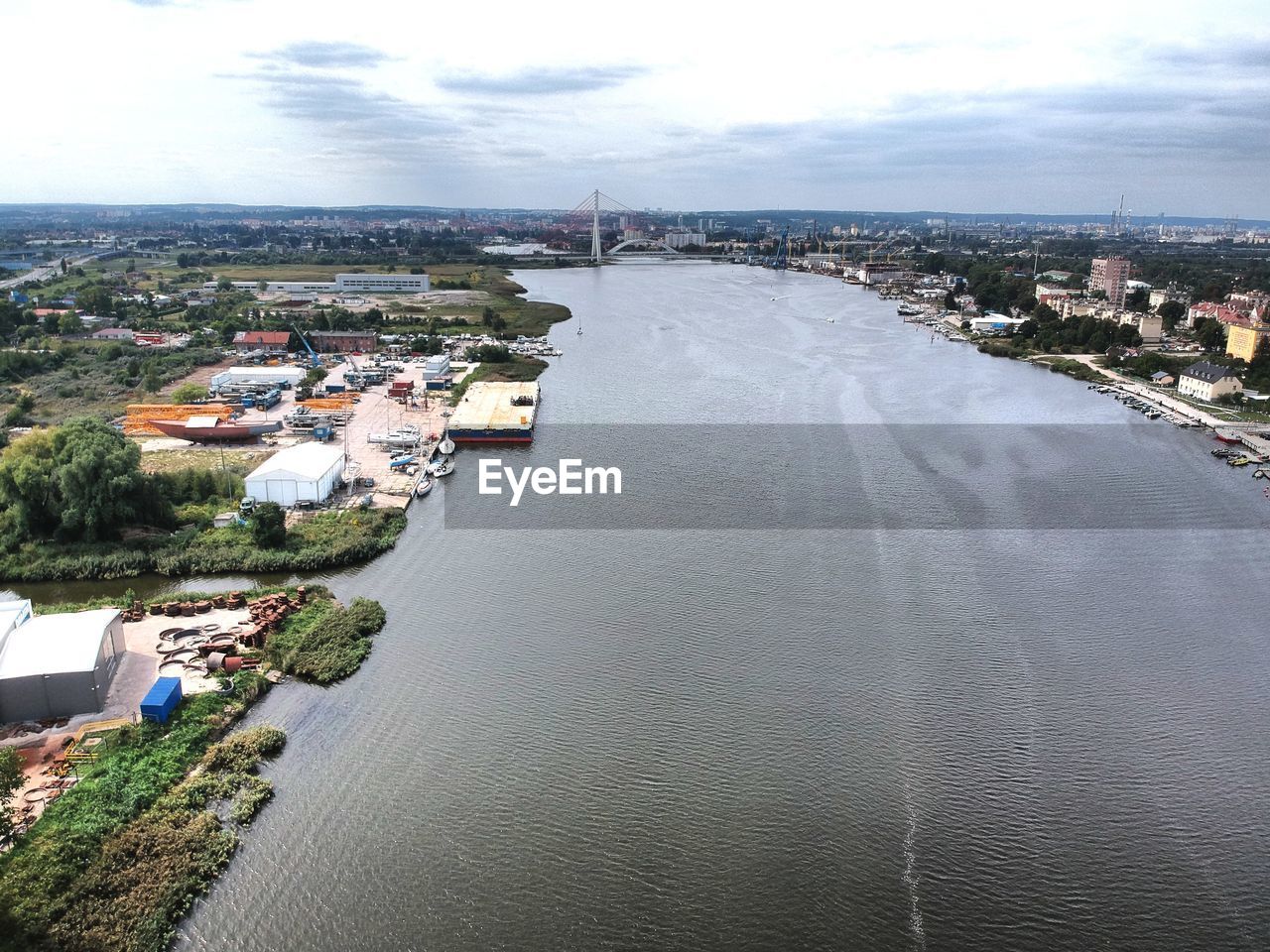 HIGH ANGLE VIEW OF RIVER BY BUILDINGS AGAINST SKY