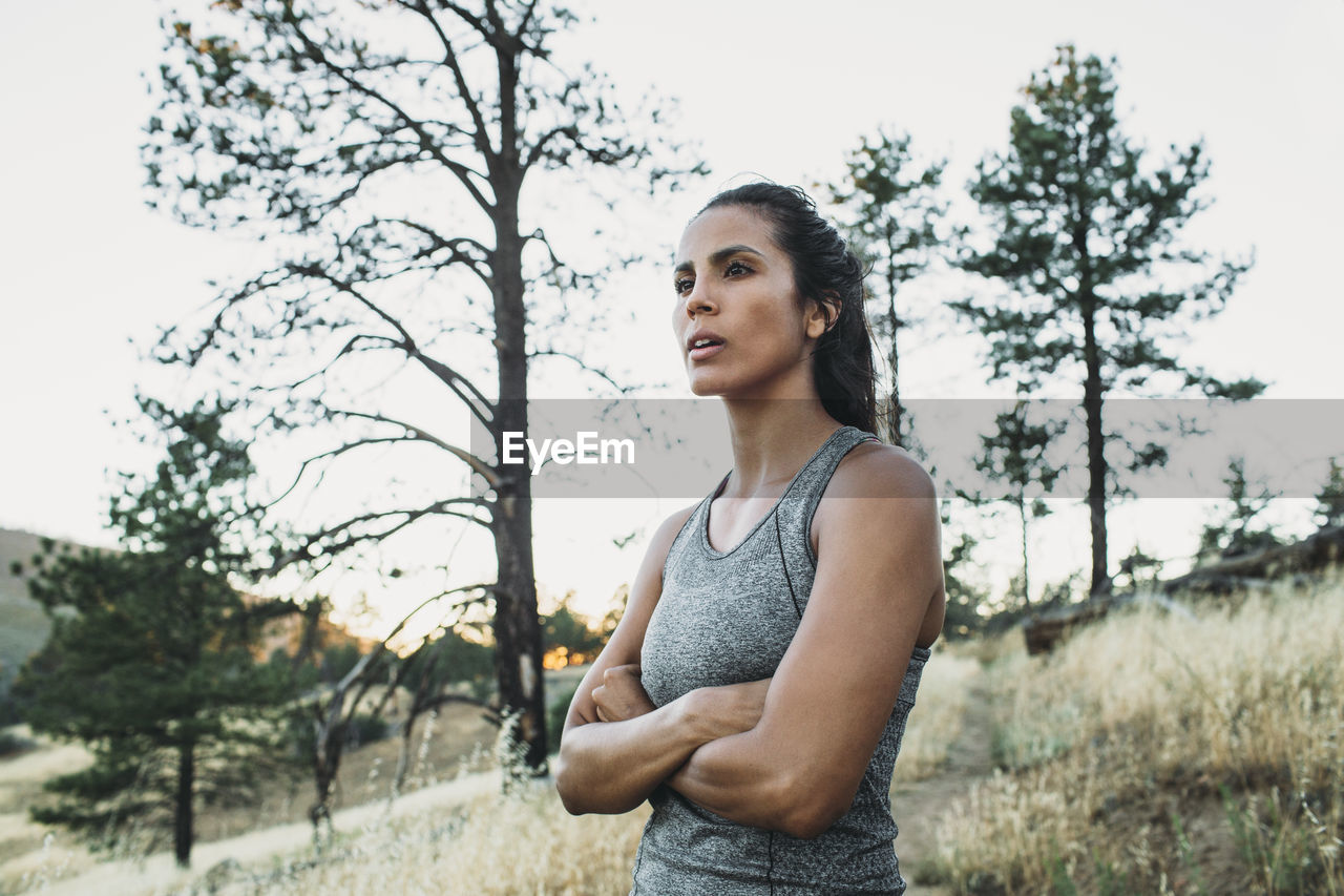 Sportswoman with arms crossed standing on field