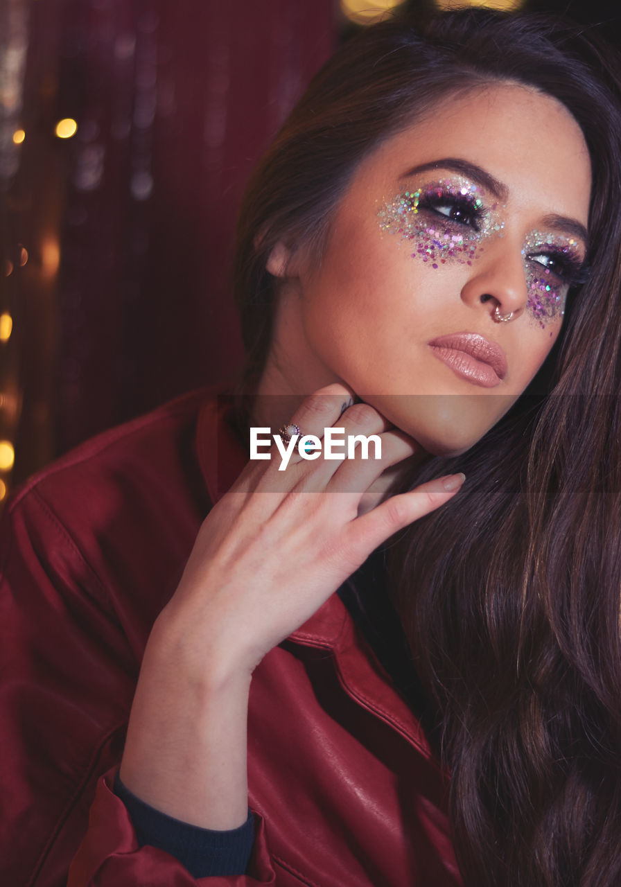 Thoughtful young woman with glitter eye make-up