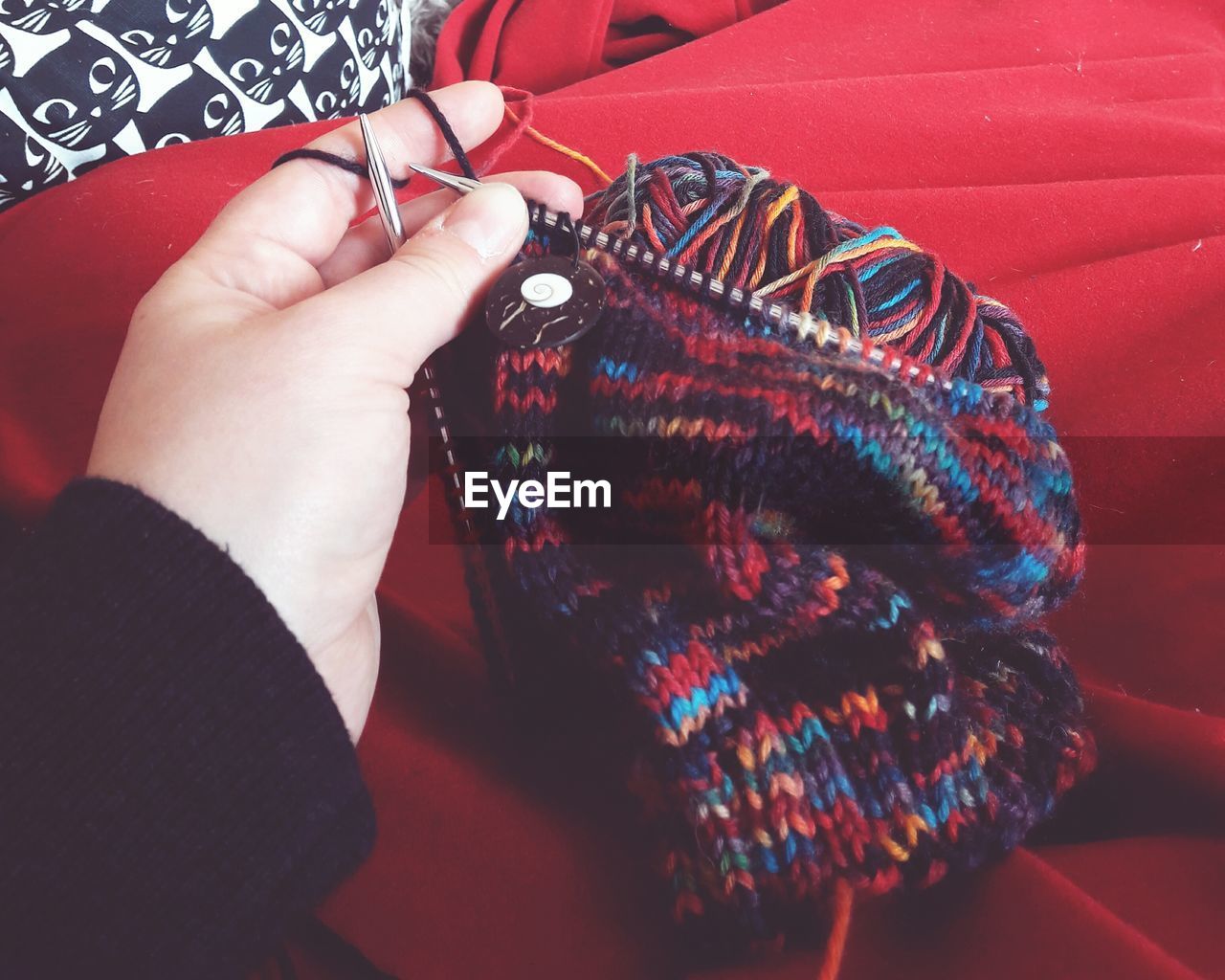 Cropped hand of woman knitting hat