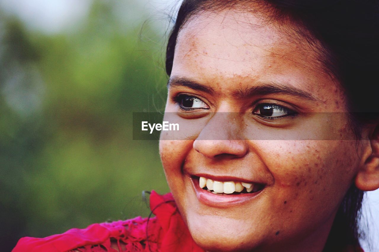 Close-up of smiling woman looking away