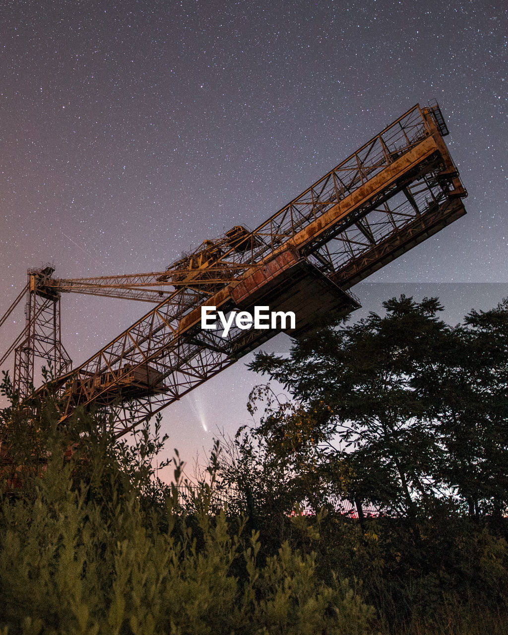 Low angle view of crane against sky at night