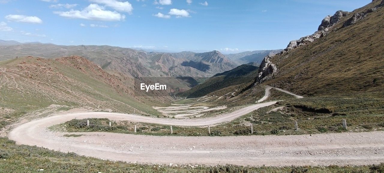 high angle view of road by mountains against sky