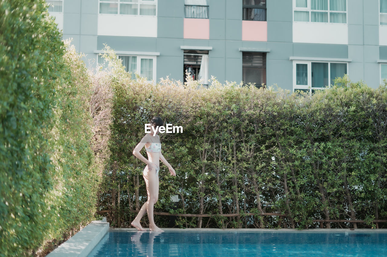 Woman standing by swimming pool