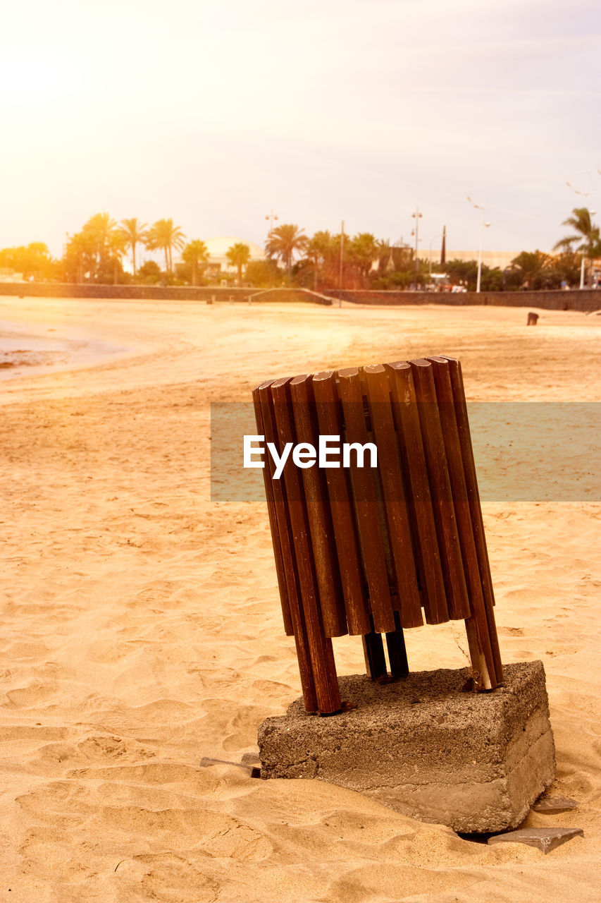 DECK CHAIRS ON SAND AT BEACH AGAINST SKY