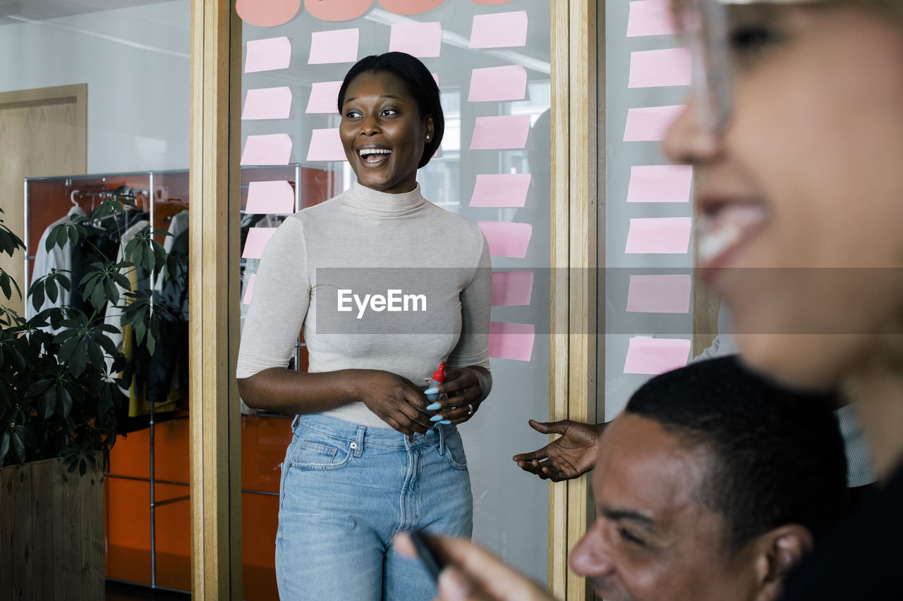 Female business professional laughing during meeting with colleagues at office