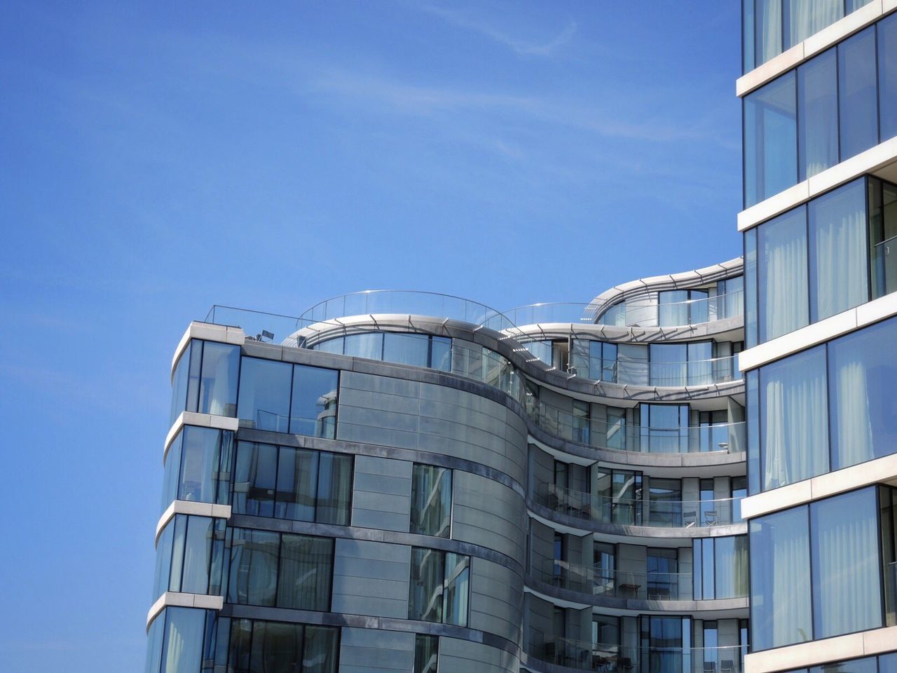 Low angle view of modern building against blue sky