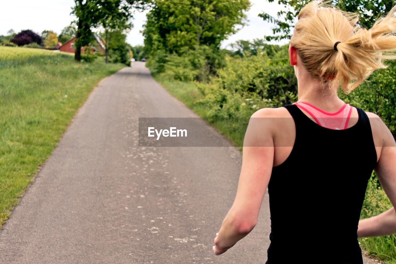 Rear view of a woman jogging on pathway