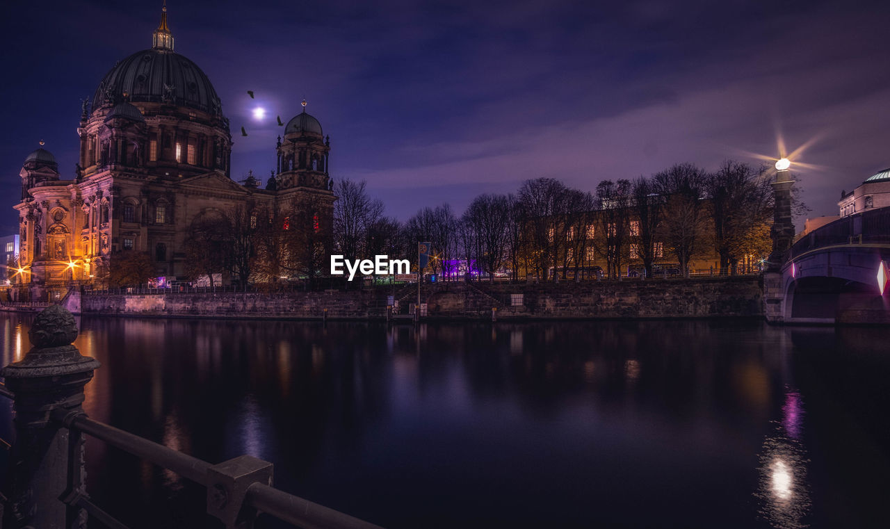 River by berlin cathedral in illuminated city at night