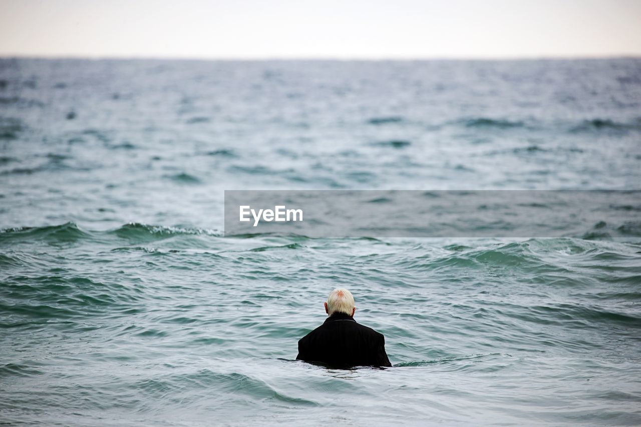 Rear view of man swimming in sea