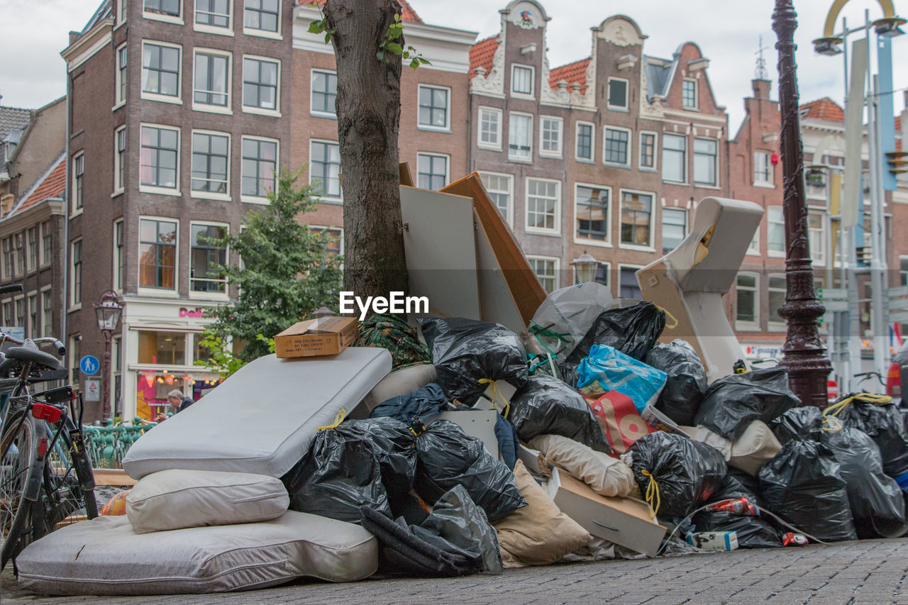 Heap of garbage on sidewalk against building in city