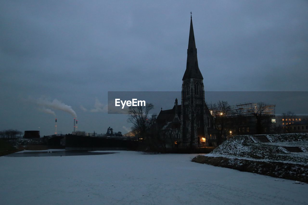 VIEW OF ILLUMINATED BUILDING AGAINST SKY DURING WINTER