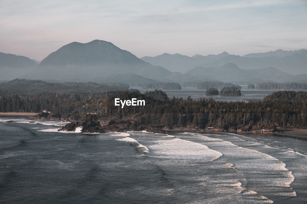 Scenic view of sea and mountains against sky