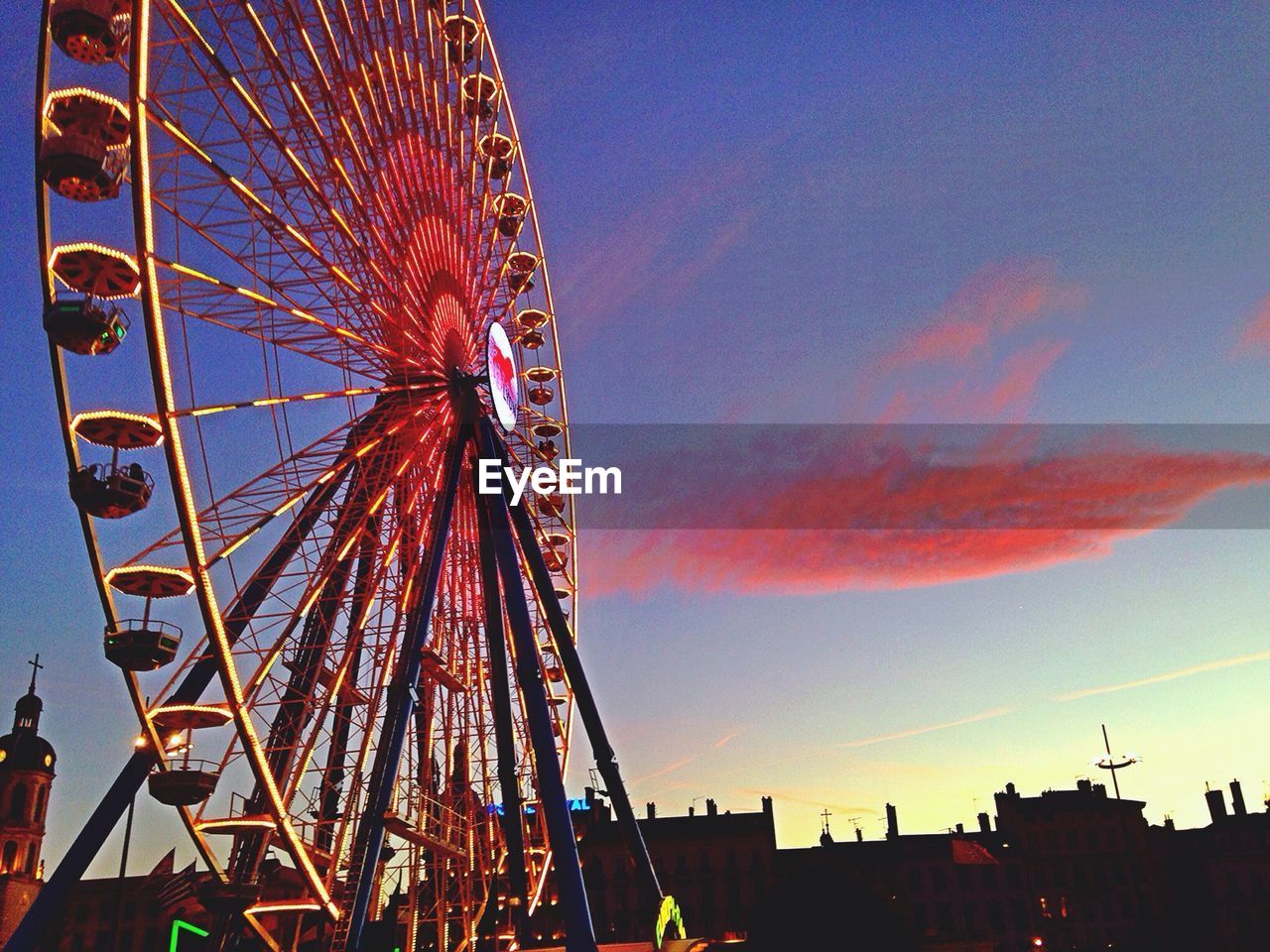 LOW ANGLE VIEW OF FERRIS WHEEL AGAINST SKY AT DUSK
