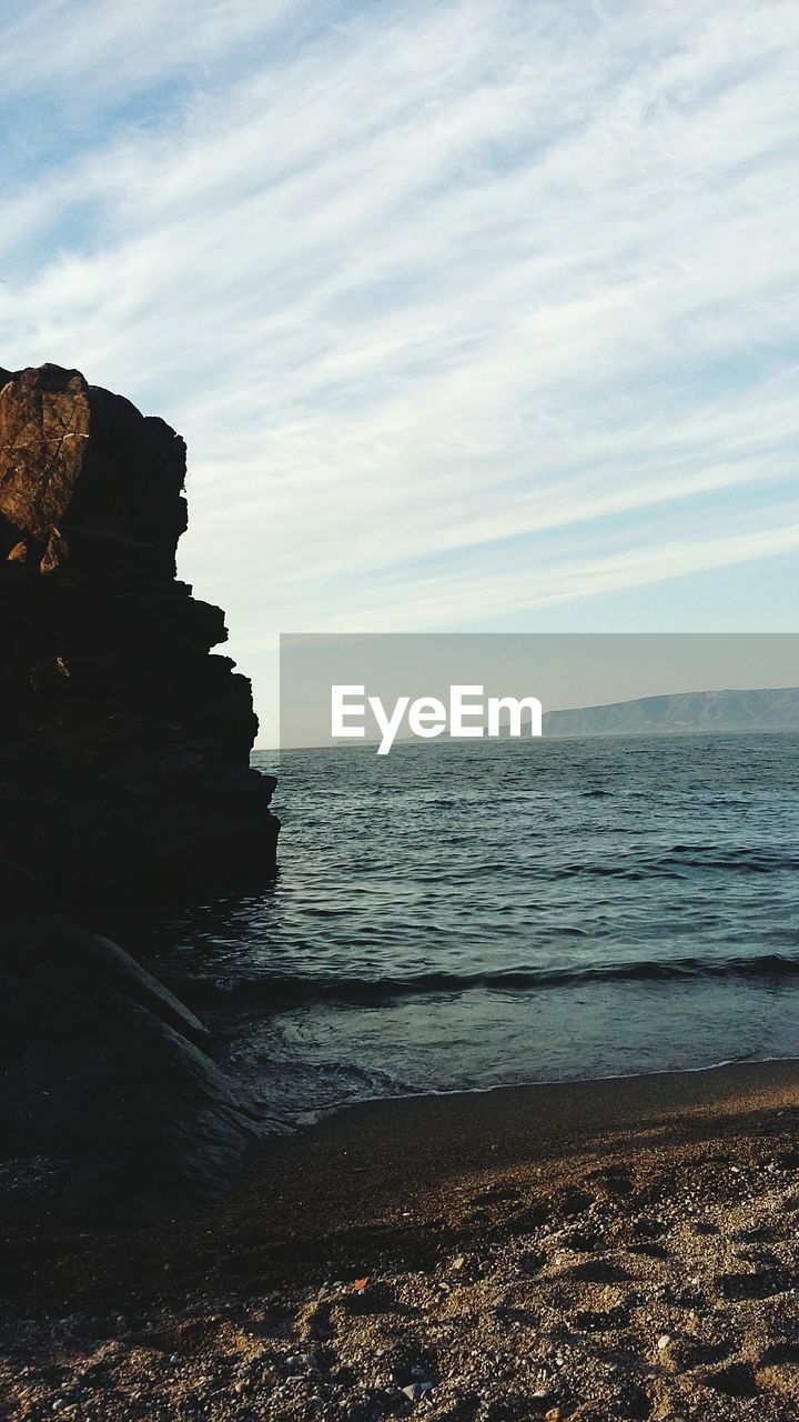 SCENIC VIEW OF ROCKS ON BEACH AGAINST SKY