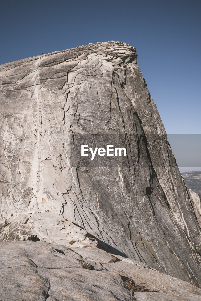 Climbers ascending cable secured section of half dome in yosemite np