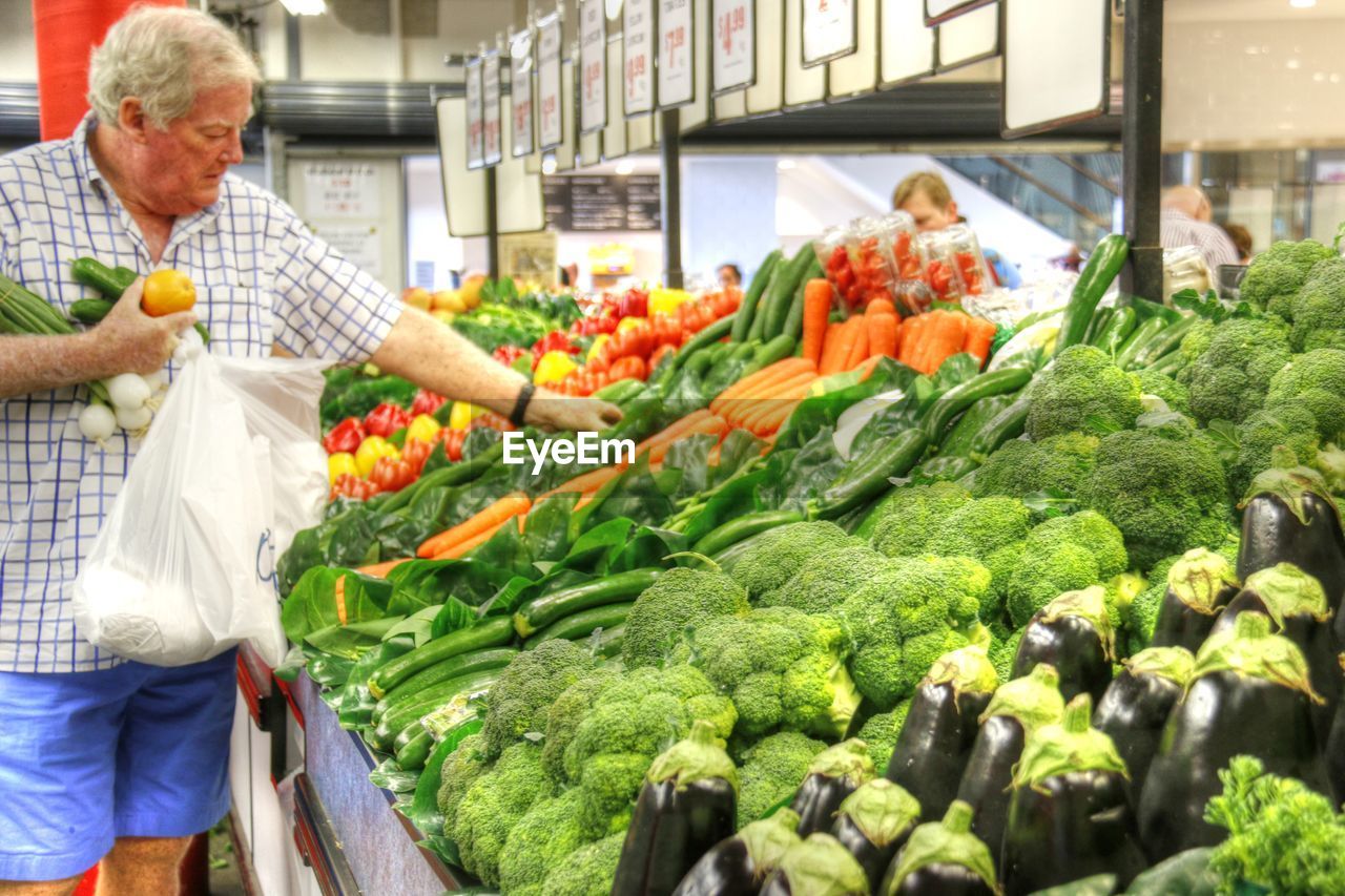 MIDSECTION OF MAN AND WOMAN AT MARKET STALL