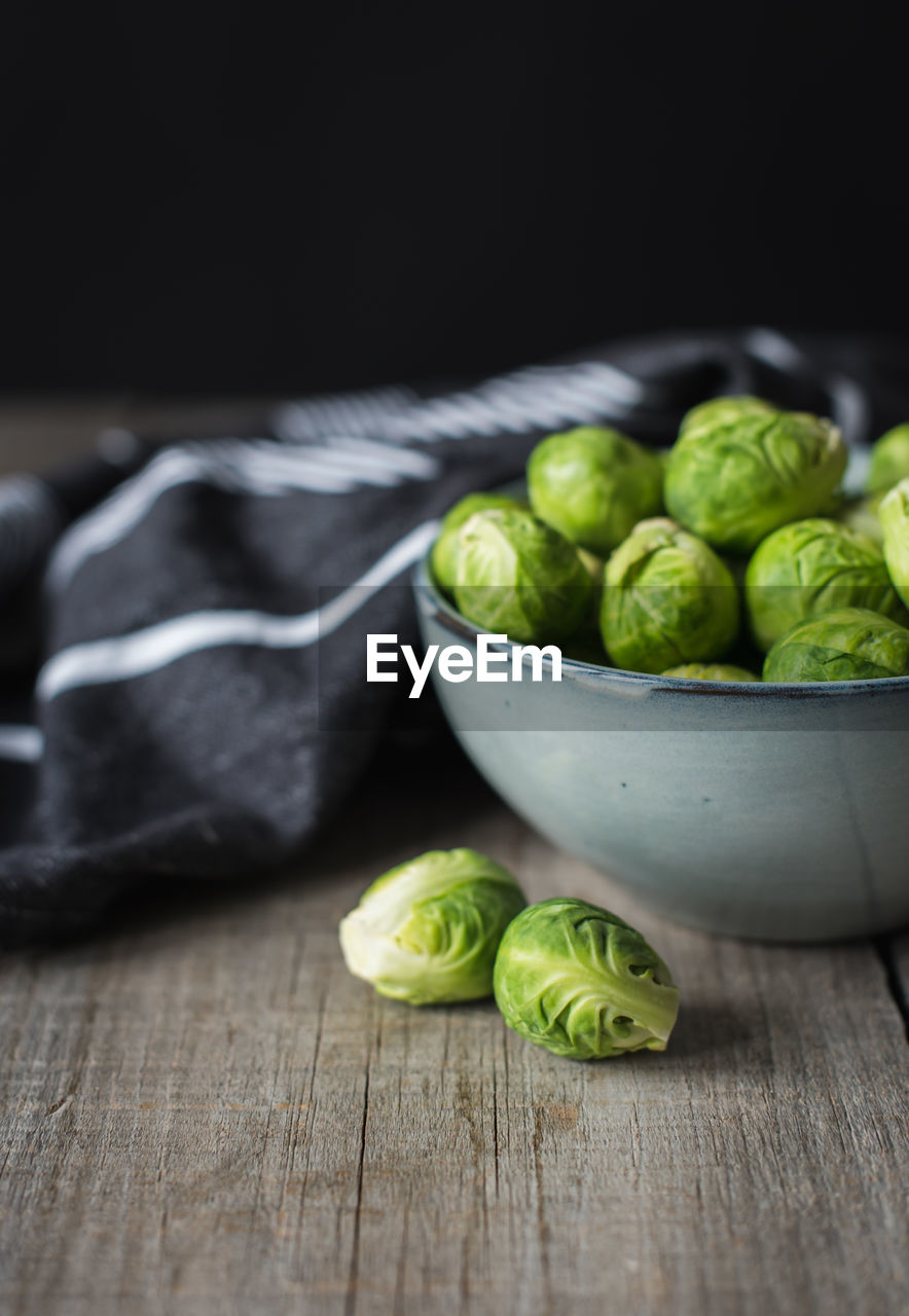 Bowl of brussels sprouts and napkin on a rustic wooden table.