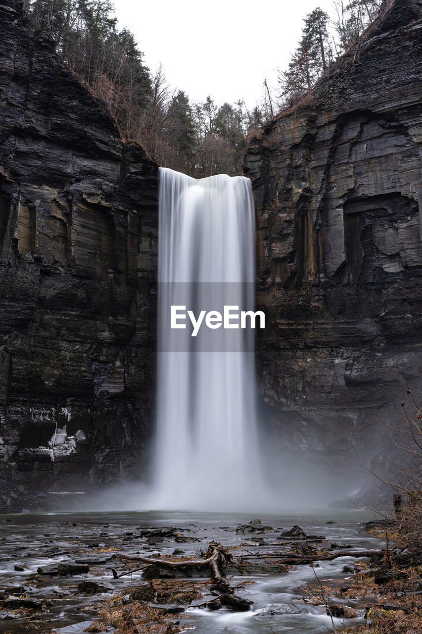 VIEW OF WATERFALL WITH ROCKS IN BACKGROUND