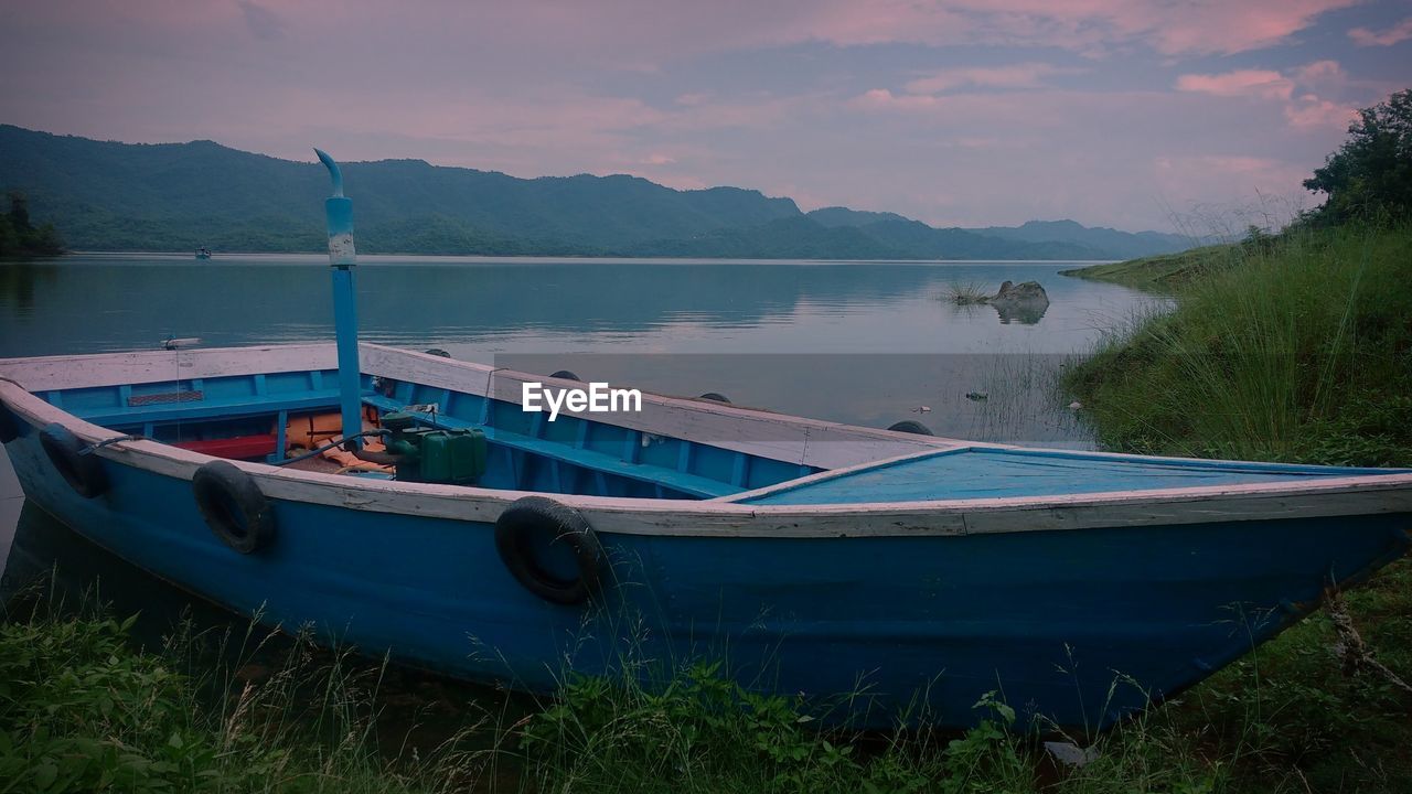 Boats moored in lake against sky